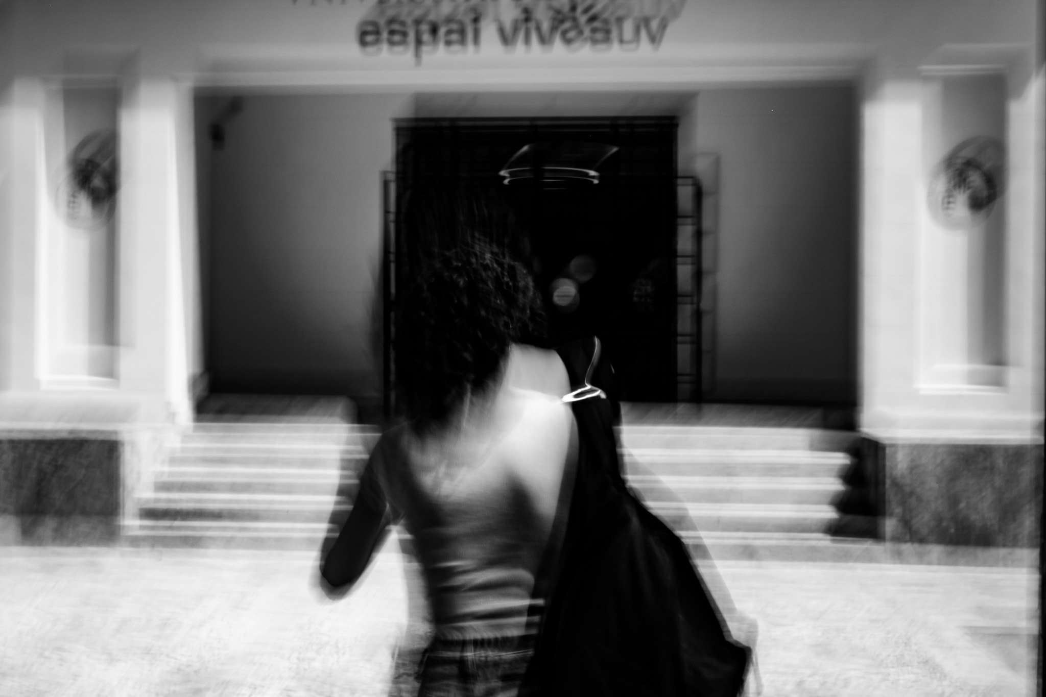 Una figura en movimiento ante la entrada de Espai Vives