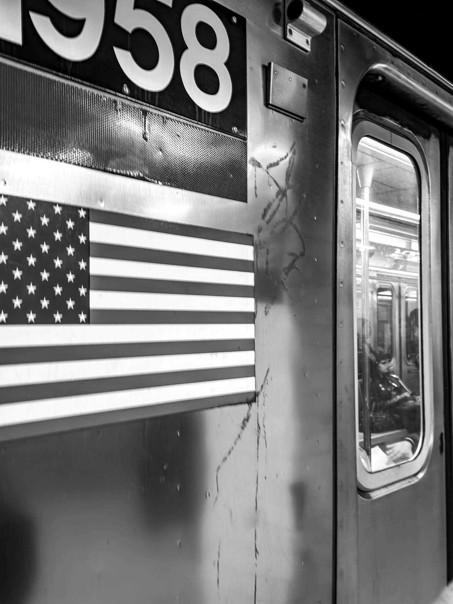 Vagón de metro con bandera estadounidense y una pasajera